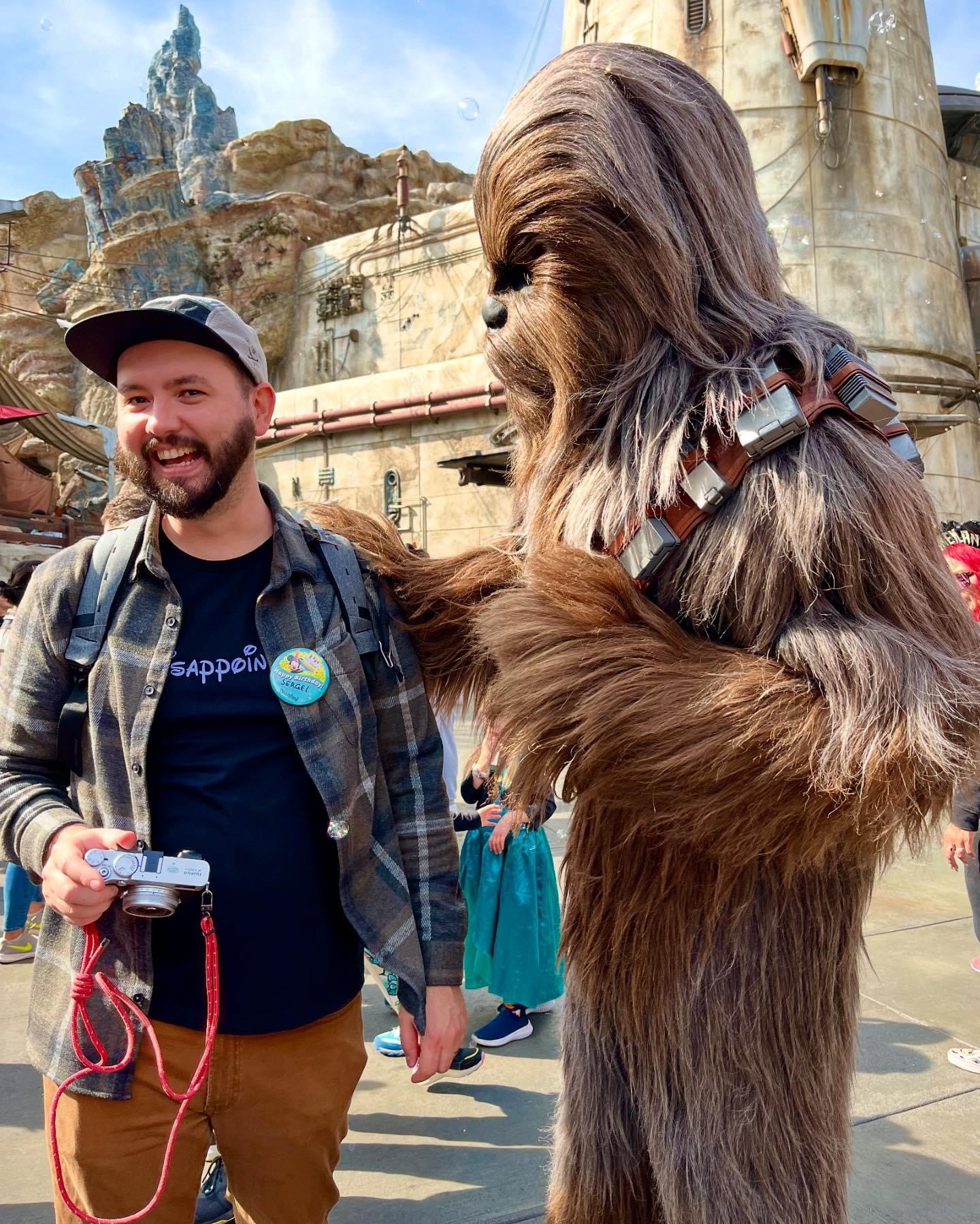 Photo of a man in a theme park with Chewbaka